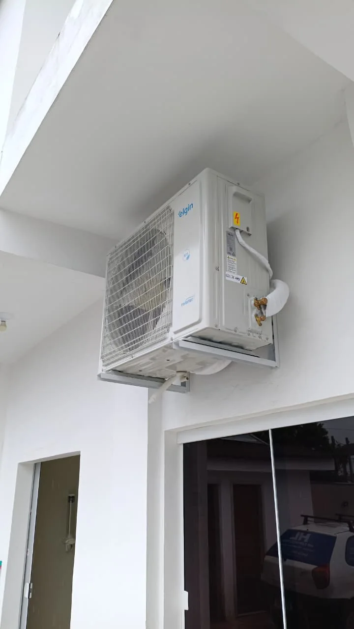 Vista lateral de uma unidade externa de ar-condicionado instalada em suporte